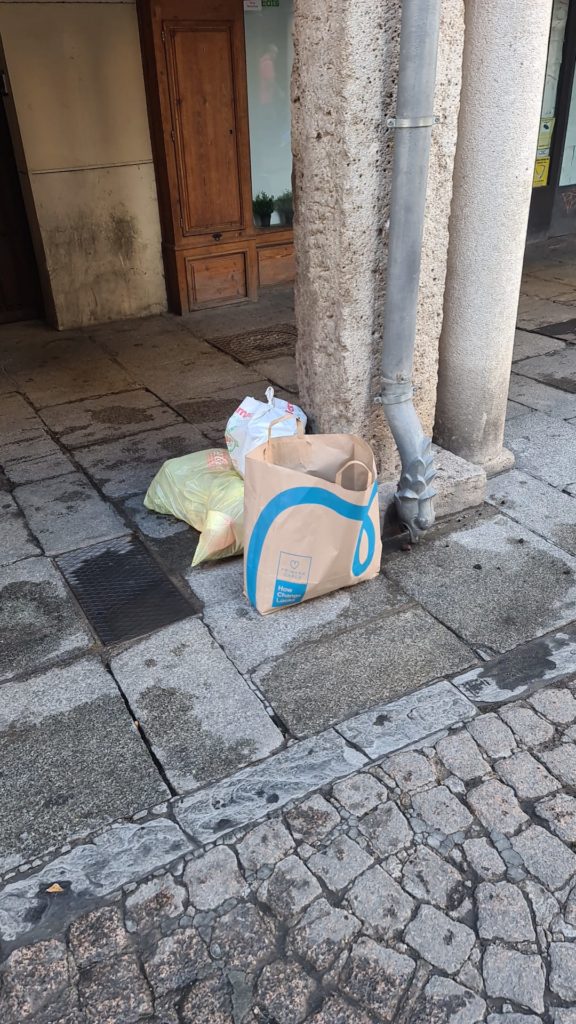 Restos de basura junto a una columna en la calle Mayor