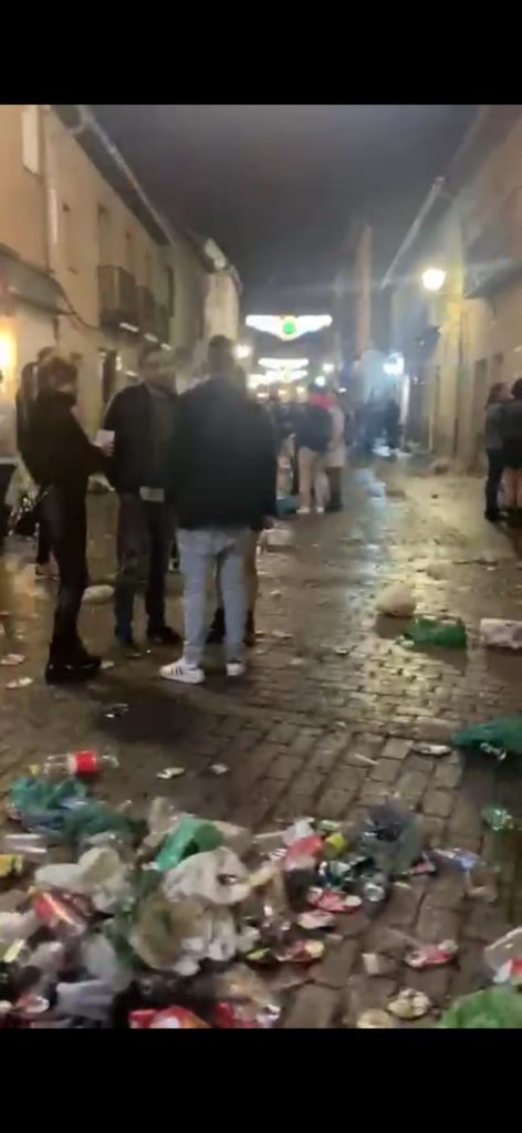 Personas en la calle rodeadas de residuos